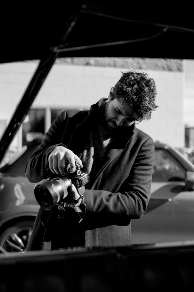 Noah Dach checking a camera in black and white